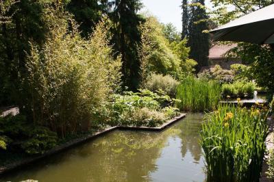 Chambre avec lit double, baignoire îlot, parquet, carrelage hexagonal et échelle porte-serviettes.