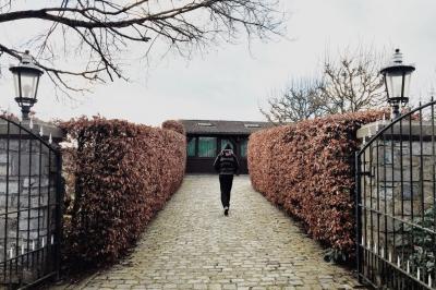 Chambre avec lit double, baignoire îlot, parquet, carrelage hexagonal et échelle porte-serviettes.