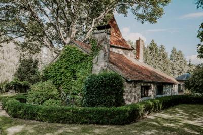Chambre avec lit double, baignoire îlot, parquet, carrelage hexagonal et échelle porte-serviettes.