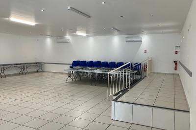 Plan d’un bâtiment avec disposition des pièces, entrées, parking et espaces extérieurs indiqués.