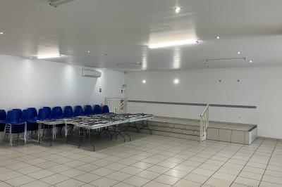 Plan d’un bâtiment avec disposition des pièces, entrées, parking et espaces extérieurs indiqués.