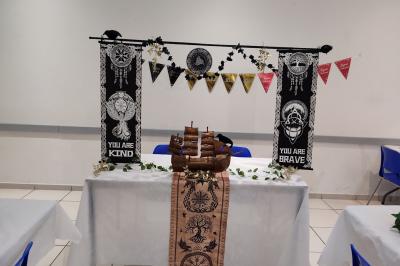 Plan d’un bâtiment avec disposition des pièces, entrées, parking et espaces extérieurs indiqués.