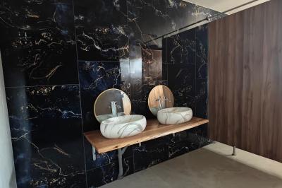 Allée décorée de fleurs blanches dans une salle en pierre éclairée par des guirlandes lumineuses.