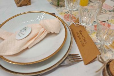 Allée décorée de fleurs blanches dans une salle en pierre éclairée par des guirlandes lumineuses.