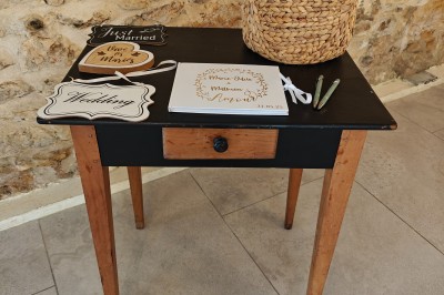 Allée décorée de fleurs blanches dans une salle en pierre éclairée par des guirlandes lumineuses.