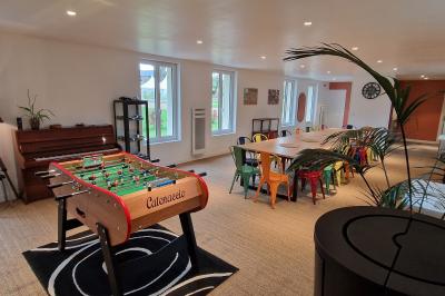 Des convives discutent près d'un barbecue en plein air, sous des parasols éclairés, dans une ambiance nocturne festive.