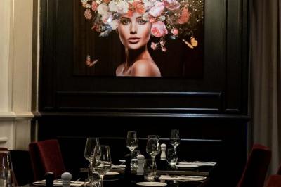 Plat italien gratiné avec sauce tomate, fromage fondu et feuilles de basilic, présenté dans un plat noir.