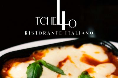 Plat italien gratiné avec sauce tomate, fromage fondu et feuilles de basilic, présenté dans un plat noir.