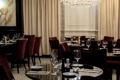 Plat italien gratiné avec sauce tomate, fromage fondu et feuilles de basilic, présenté dans un plat noir.