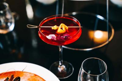Plat italien gratiné avec sauce tomate, fromage fondu et feuilles de basilic, présenté dans un plat noir.