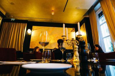 Plat italien gratiné avec sauce tomate, fromage fondu et feuilles de basilic, présenté dans un plat noir.