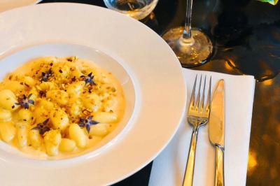 Un comptoir décoratif avec des objets design, éclairé par une lumière chaleureuse et entouré de rideaux blancs.