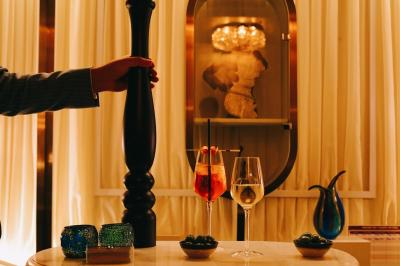 Un comptoir décoratif avec des objets design, éclairé par une lumière chaleureuse et entouré de rideaux blancs.