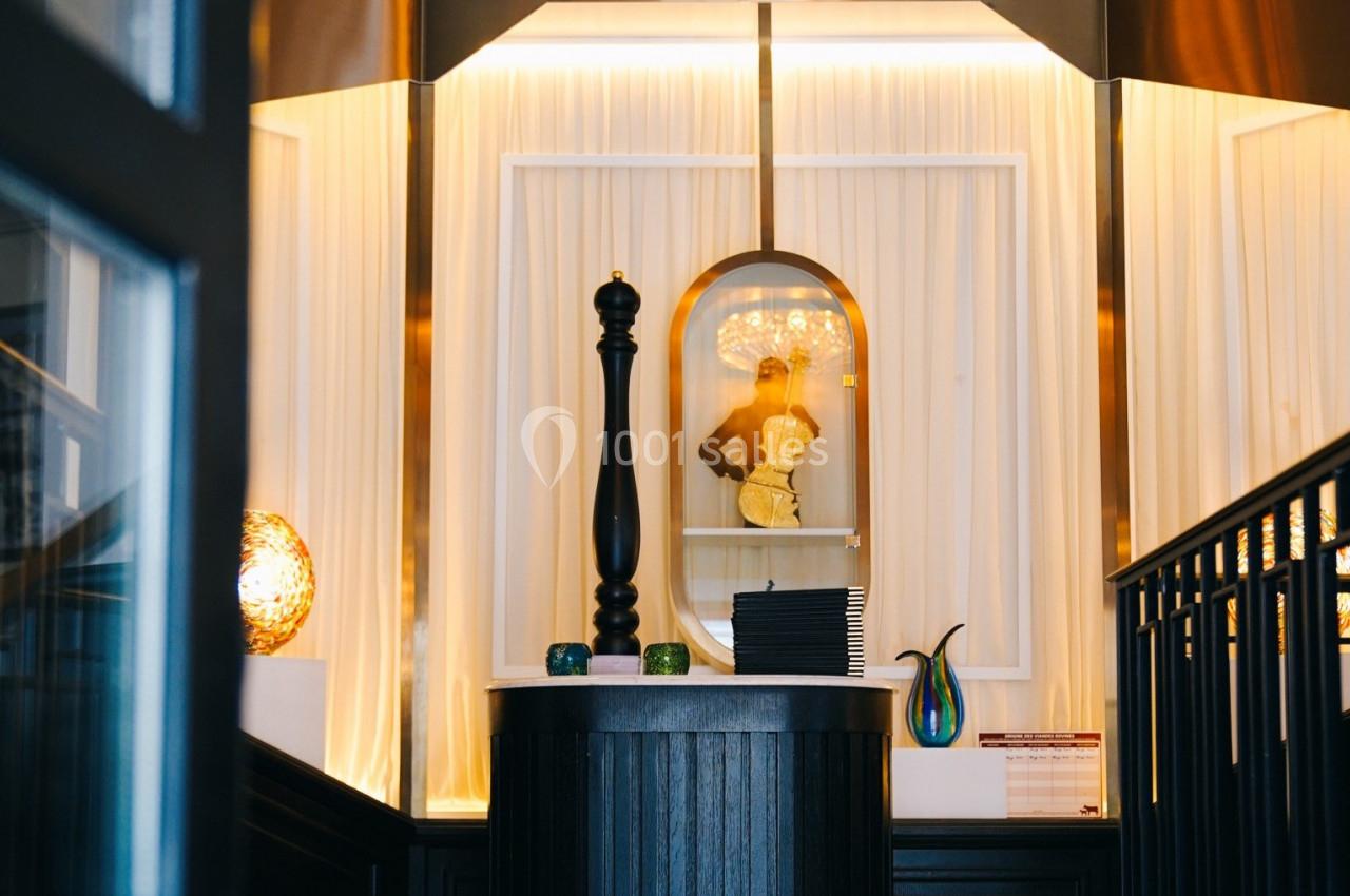 Un comptoir décoratif avec des objets design, éclairé par une lumière chaleureuse et entouré de rideaux blancs.