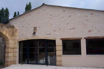 Ardoise décorative accrochée à une grille en fer forgé, entourée de végétation et d'un voile blanc.