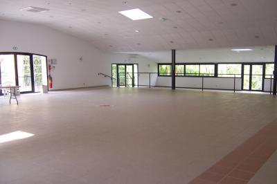 Ardoise décorative accrochée à une grille en fer forgé, entourée de végétation et d'un voile blanc.