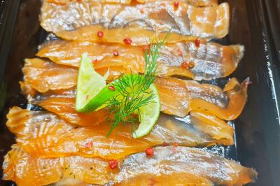 Tranches de saumon fumé garnies de rondelles de citron vert, brins d'aneth et baies roses.