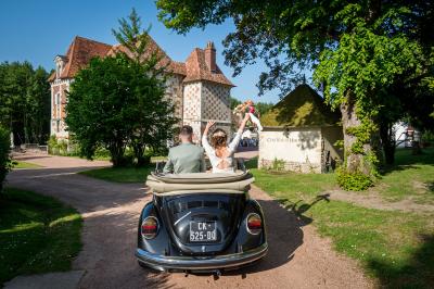 Salle spacieuse avec canapés, baby-foot, table de jeux et grandes fenêtres donnant sur un extérieur arboré.