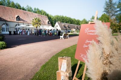 Salle spacieuse avec canapés, baby-foot, table de jeux et grandes fenêtres donnant sur un extérieur arboré.