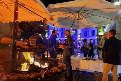 Salle spacieuse avec canapés, baby-foot, table de jeux et grandes fenêtres donnant sur un extérieur arboré.