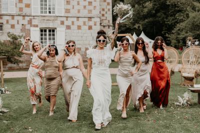 Salle spacieuse avec canapés, baby-foot, table de jeux et grandes fenêtres donnant sur un extérieur arboré.