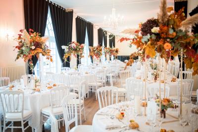 Salle spacieuse avec canapés, baby-foot, table de jeux et grandes fenêtres donnant sur un extérieur arboré.
