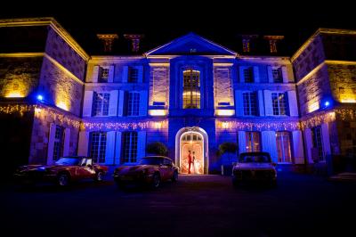 Salle spacieuse avec canapés, baby-foot, table de jeux et grandes fenêtres donnant sur un extérieur arboré.