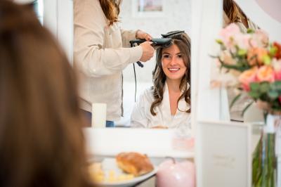 Salle spacieuse avec canapés, baby-foot, table de jeux et grandes fenêtres donnant sur un extérieur arboré.