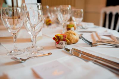 Salle spacieuse avec canapés, baby-foot, table de jeux et grandes fenêtres donnant sur un extérieur arboré.