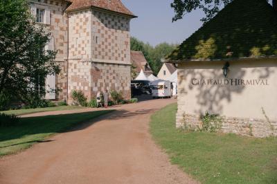 Salle spacieuse avec canapés, baby-foot, table de jeux et grandes fenêtres donnant sur un extérieur arboré.