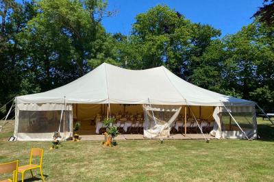 Cuisine professionnelle équipée avec plaques de cuisson, étagères, réfrigérateur, évier et équipements de sécurité visibles.