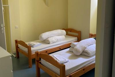 Cuisine professionnelle équipée avec plaques de cuisson, étagères, réfrigérateur, évier et équipements de sécurité visibles.