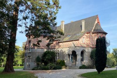 Cuisine professionnelle équipée avec plaques de cuisson, étagères, réfrigérateur, évier et équipements de sécurité visibles.