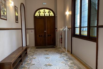 Cuisine professionnelle équipée avec plaques de cuisson, étagères, réfrigérateur, évier et équipements de sécurité visibles.