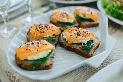 Assiette de dessert composée de crème glacée, purée orange, garnitures croquantes et feuilles de menthe.