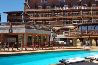 Logo du Grand Hôtel Serre Chevalier avec un dessin stylisé de montagne en noir et blanc.