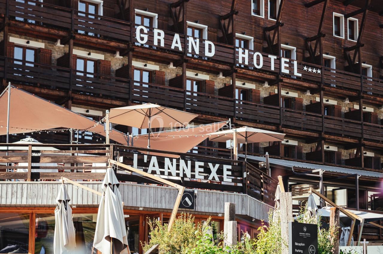 Façade en bois d'un hôtel avec balcons, terrasses ombragées et enseignes ’Grand Hôtel’ et ’L'Annexe’.