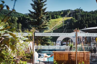 Logo du Grand Hôtel Serre Chevalier avec un dessin stylisé de montagne en noir et blanc.
