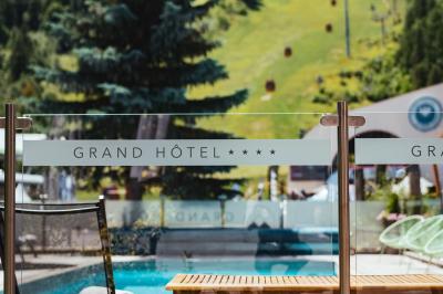 Logo du Grand Hôtel Serre Chevalier avec un dessin stylisé de montagne en noir et blanc.