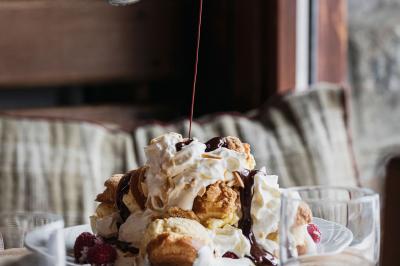 Un dessert composé d'un gâteau aux fruits rouges, accompagné de crème et de baies, présenté sur une terrasse en hiver.