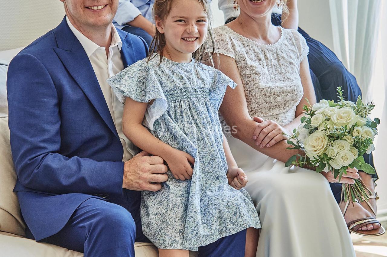 Une famille souriante posant dans un salon, les parents assis avec leurs enfants autour d'eux.
