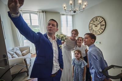 Un grand groupe de personnes souriantes levant les bras, rassemblées dans un parc pour une célébration.
