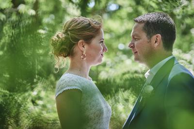 Un grand groupe de personnes souriantes levant les bras, rassemblées dans un parc pour une célébration.