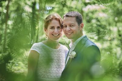 Un grand groupe de personnes souriantes levant les bras, rassemblées dans un parc pour une célébration.
