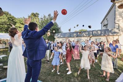 Un grand groupe de personnes souriantes levant les bras, rassemblées dans un parc pour une célébration.