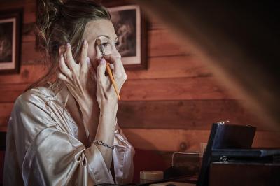 Un grand groupe de personnes souriantes levant les bras, rassemblées dans un parc pour une célébration.