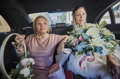 Un grand groupe de personnes souriantes levant les bras, rassemblées dans un parc pour une célébration.