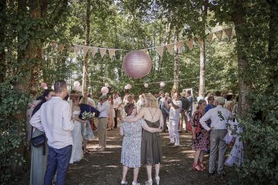 Un grand groupe de personnes souriantes levant les bras, rassemblées dans un parc pour une célébration.