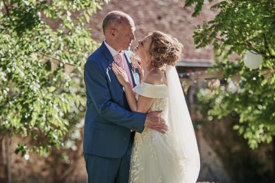 Un grand groupe de personnes souriantes levant les bras, rassemblées dans un parc pour une célébration.