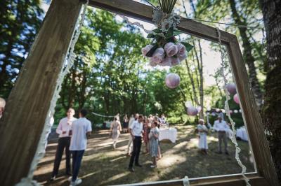 Un grand groupe de personnes souriantes levant les bras, rassemblées dans un parc pour une célébration.